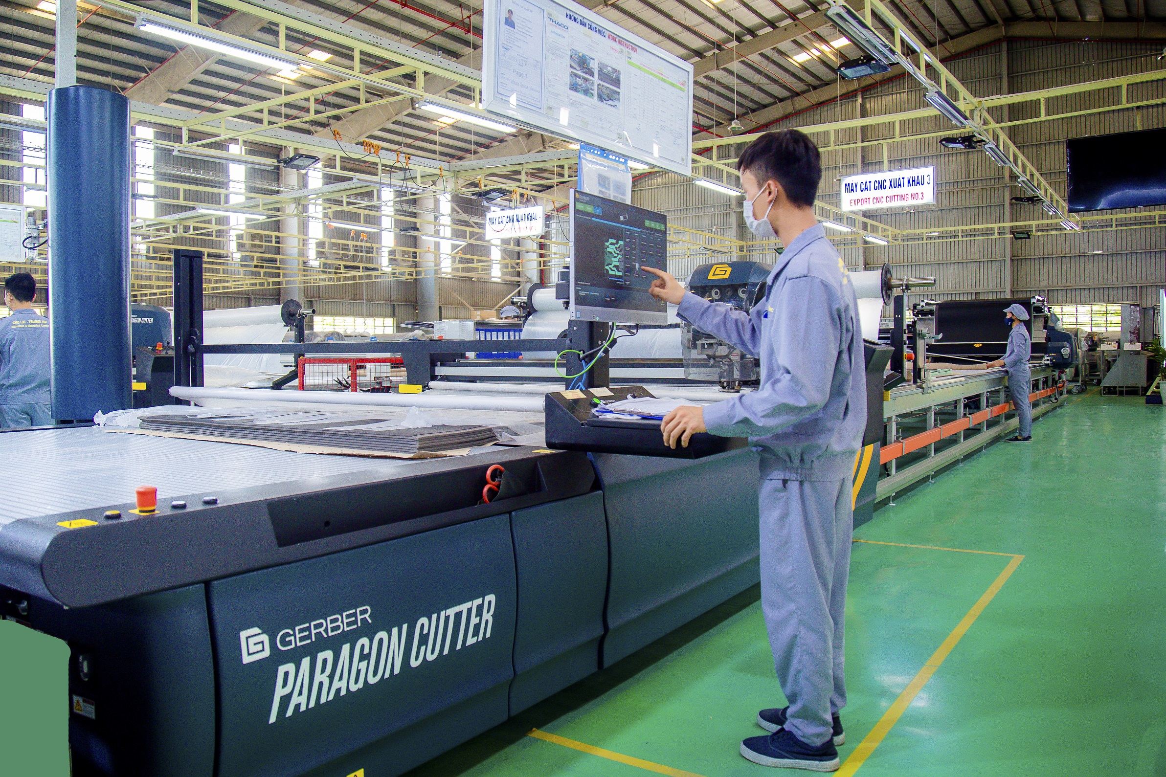 Công nhân điều khiển máy cắt vải CNC tại nhà máy Ghế ô tô