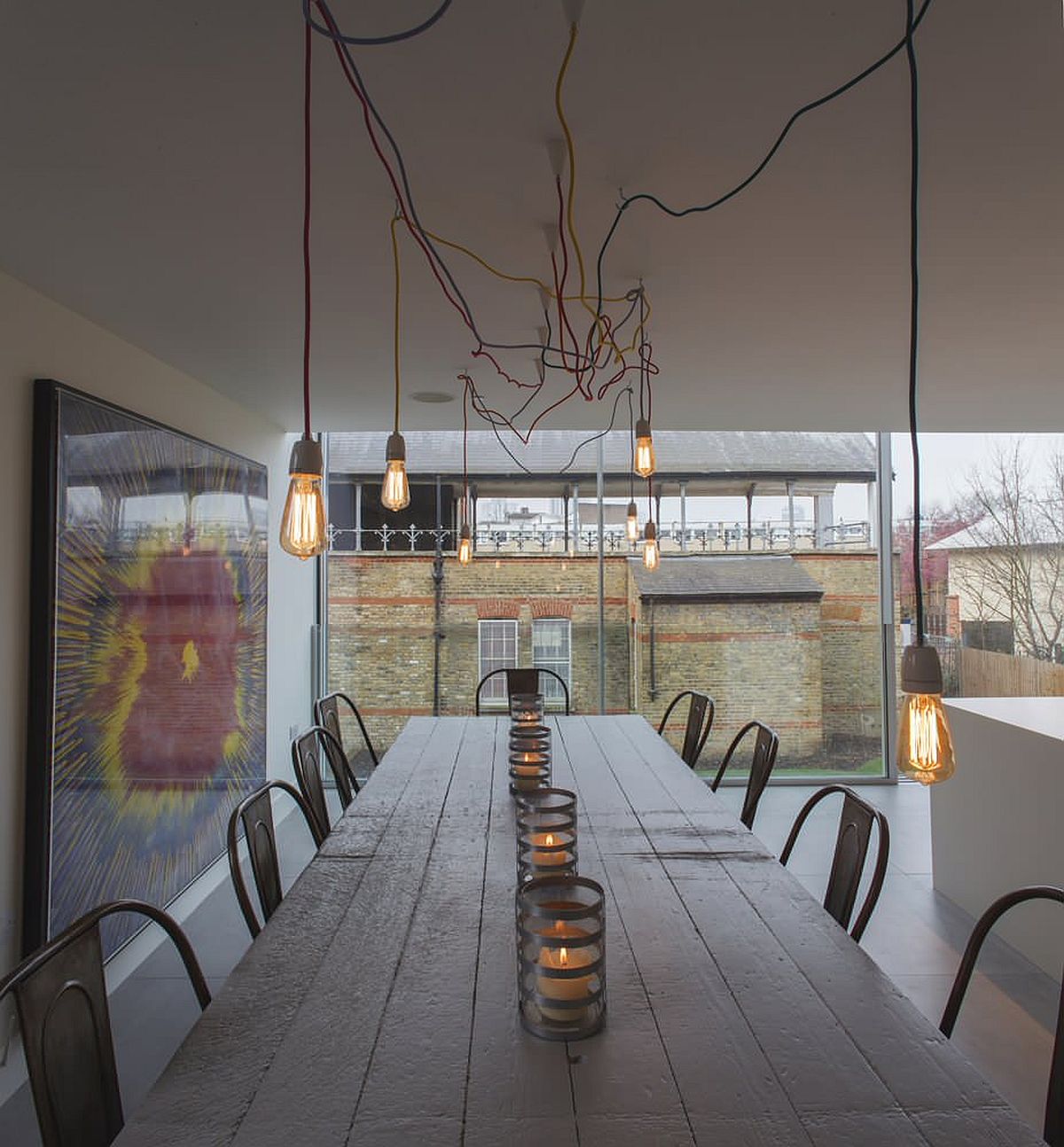 Hệ thống chiếu sáng bằng bóng đèn Edison tạo thêm nét công nghiệp cho không gian ăn uống tối giản hiện đại này