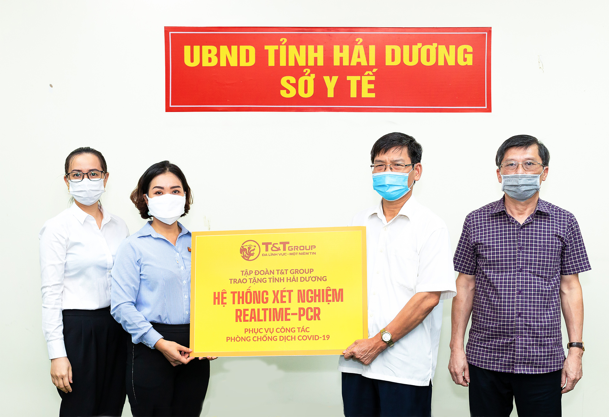 Đại diện Tập đoàn T&T Group (bên trái) trao tặng hệ thống máy xét nghiệm Realtime - PCR cho đại diện Sở Y tế Hải Dương (bên phải)