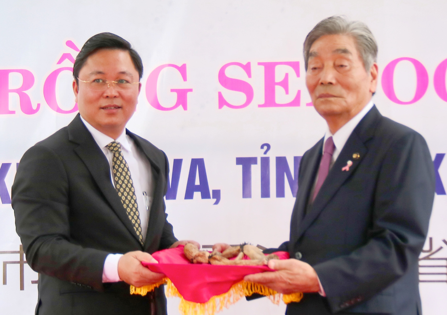 Ông Lê Trí Thanh (bên trái) Chủ tịch UBND tỉnh Quảng Nam nhận hoa sen từ đại diện nước Nhật Bản. Ảnh: HỮU TRÀ
