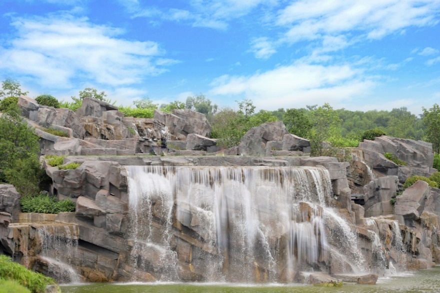 Great Falls Park over rocks with trees and blue sky  Description automatically generated