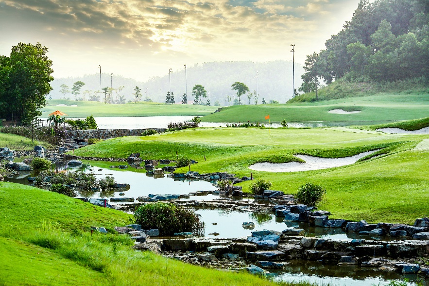 A river running through a golf course  Description automatically generated