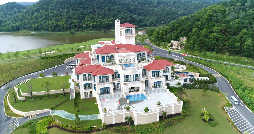 A large white house with a pool in front of it  Description automatically generated