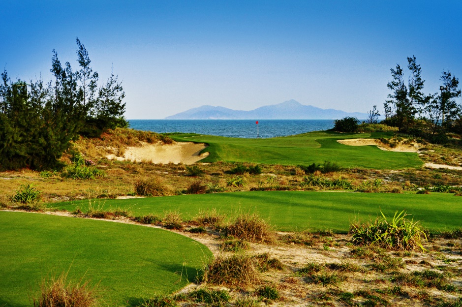 A golf course with a view of the ocean  Description automatically generated