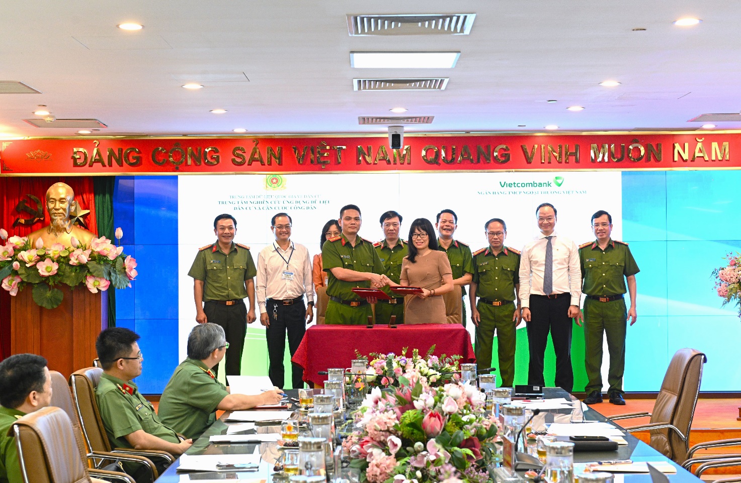 A group of people in uniform standing in front of a table  Description automatically generated