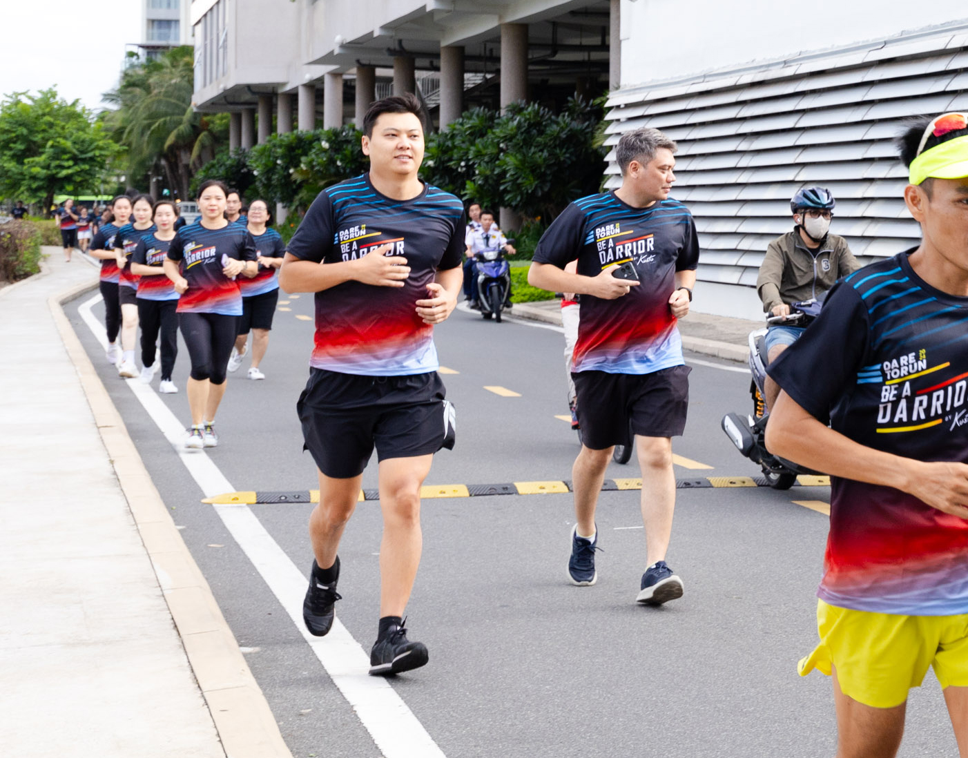 A group of people running on a street  Description automatically generated