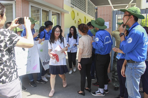 Các em học sinh rời phòng thi và ra đến cổng trường thì được đội tình nguyện vỗ tay chúc mừng.