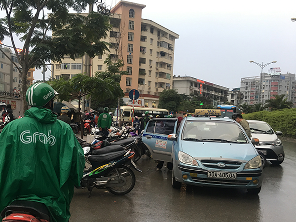 Cánh tài xế xe ôm, taxi tất bật đón trả khách trước cổng bến xe.