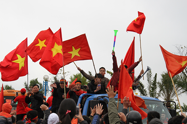 Người hâm mộ giương cao cờ đỏ sao vàng chúc mừng chiến công của U23 Việt Nam suốt dọc 30km đường đi.