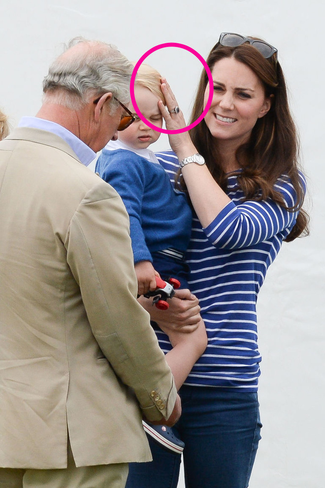 Hành động vuốt tóc hay xoa đầu Hoàng tử George không chỉ là cách quan tâm mà còn là cách mẹ Kate bảo vệ con khỏi ống kính máy ảnh. (Ảnh: AFP)