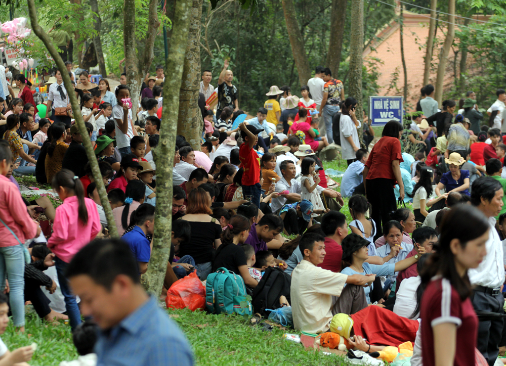 Nhiều người chọn khu vực bãi cỏ dưới chân đền để nghỉ ngơi ăn uống trong tiết trời oi bức.