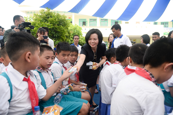 Bà Trương Thị Mai - Ủy viên Bộ Chính trị, Bí thư Trung ương Đảng, Trưởng ban Dân vận Trung ương trao những hộp sữa của Quỹ sữa vươn cao Việt Nam đến các em học sinh tham dự chương trình.