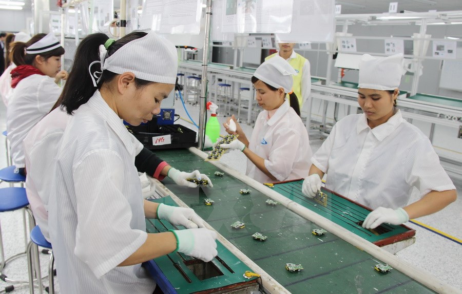 Workers at a foreign-invested firm manufacturing mobile phone spare parts in Vietnam. (Photo: VNA)