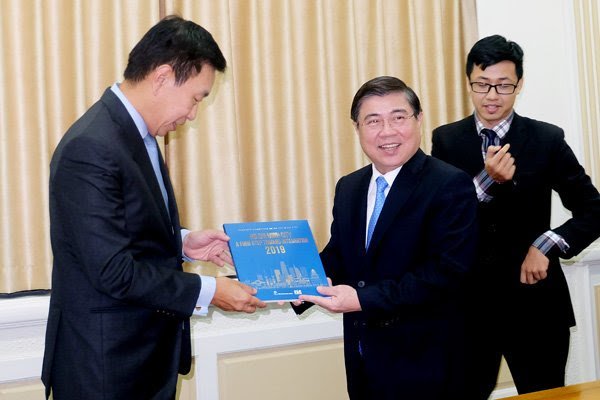 Nguyen Thanh Phong (R), HCMC chairman, gives a book about the city to Loh Chin Hua, Keppel Land chairman, after a meeting on April 5. Keppel Land plans to develop a luxury hotel in downtown HCMC. (Photo: Hung Le)