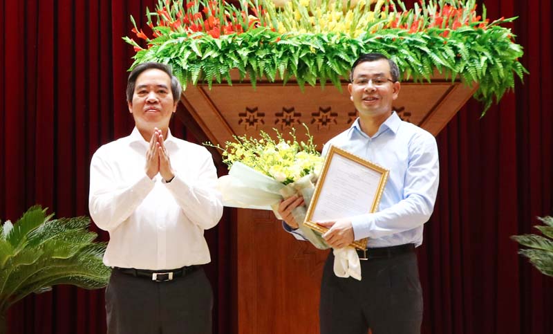 Đồng chí Nguyễn Văn Bình trao quyết định và chúc mừng đồng chí Ngô Văn Tuấn.