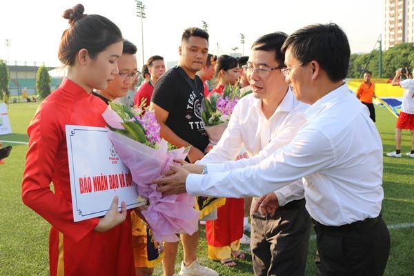 Ông Nguyễn Văn Hiếu (phía trong) và ông Hồ Minh Chiến tặng hoa và cờ lưu niệm cho các đội bóng tham dự giải.