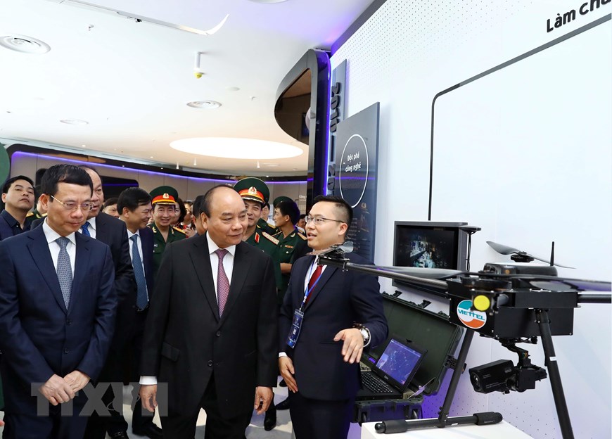 Thủ tướng Nguyễn Xuân Phúc và các đại biểu xem các gian hàng trưng bày công nghệ của tập đoàn Viettel. (Ảnh: Thống Nhất/TTXVN)