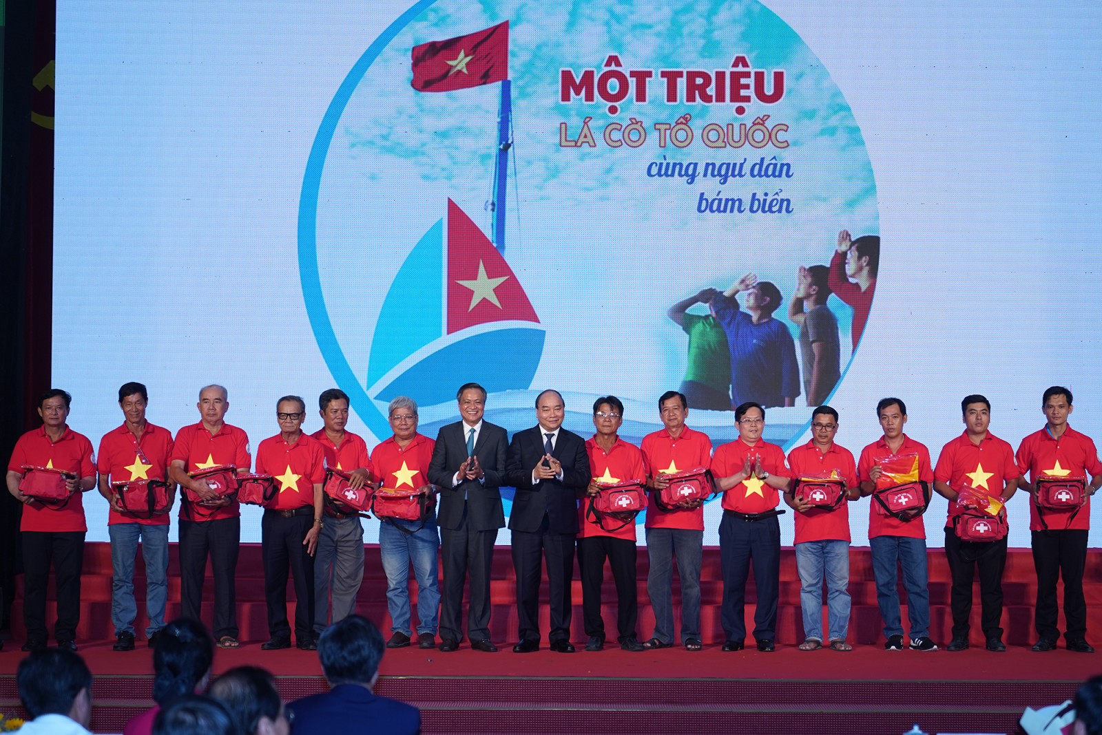 Thủ tướng trao cờ Tổ quốc và túi thiết bị y tế đi biển cho 12 ngư dân trong chương trình “Một triệu lá cờ Tổ quốc cùng ngư dân bám biển” - Ảnh: VGP/Quang Hiếu