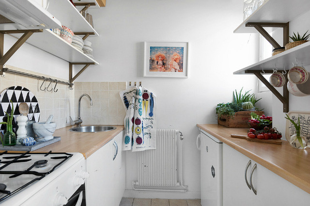 Một nhà bếp nhỏ được thiết kế kín đáo ngay cạnh bàn ăn. Bằng cách lựa chọn kệ mở thay vì những chiếc tủ bếp như thông thường, nhà bếp trông rộng rãi hơn và gây ấn tượng nhờ không gian lưu trữ không nhỏ mà chúng tạo ra.
