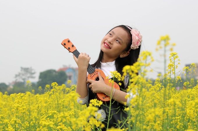 Bé Việt Hà (TP Hải Phòng) được mẹ đưa đến cánh đồng hoa cải để chụp hình.