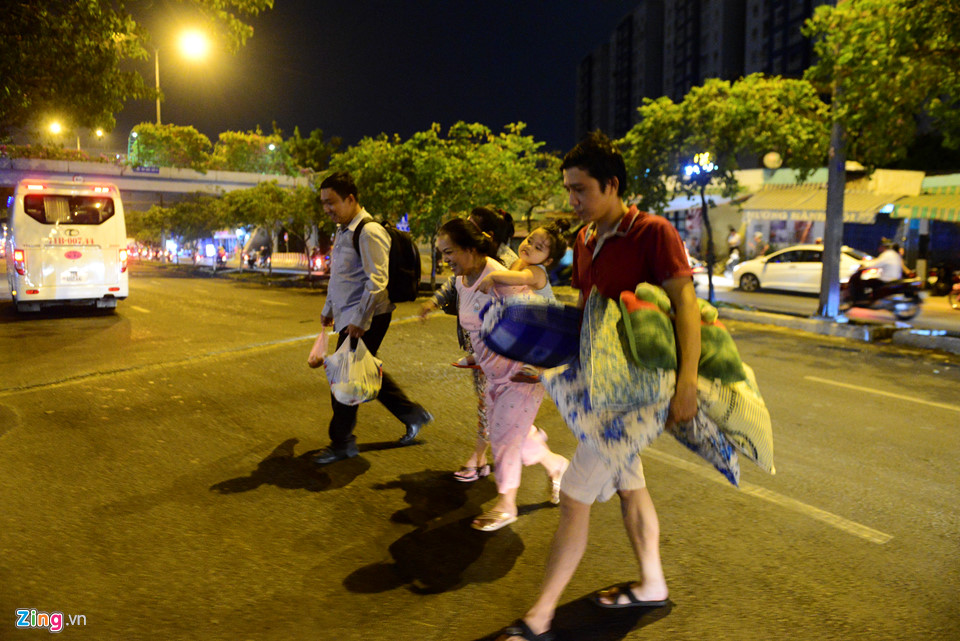 Một gia đình băng qua đường Võ Văn Kiệt để tìm đến chung cư đối diện ở tạm.