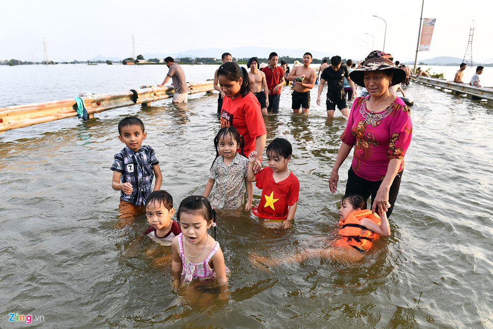 Bà Nguyễn Thị Hồng cho biết cảnh này diễn ra thường xuyên mỗi khi đường bị ngập. Hôm nay tranh thủ chiều chủ nhật, bà cho các cháu ra nghịch nước.