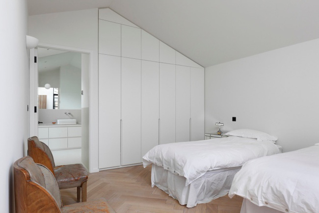 Không gian nghỉ ngơi được bố trí đơn giản với hệ thống tủ âm tường, các nội thất cơ bản được chọn lựa cùng tông nền màu trắng nhằm mở rộng không gian, giúp căn phòng mát mẻ và thông thoáng.