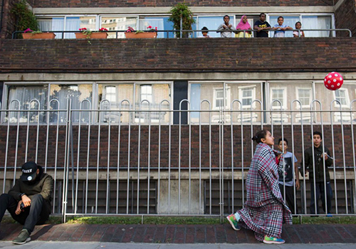 Trẻ em chơi đùa trên phố sau vụ cháy tòa chung cư Grenfell ở London, Anh, hôm 14/6. Ảnh: CNN 