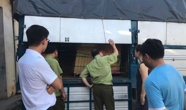 Đội Quản lý thị trường số 19 thị xã Sơn Tây (Hà Nội) đang kiểm tra và thu giữ một số lượng lớn hộp gạch lát nền nghi nhái nhãn hiệu Royal. Ảnh: PLVN