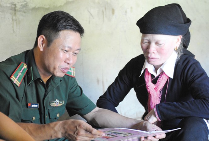 Thiếu tá Phạm Công Khanh đang luyenj chữ cho chị Phan Thị Hằng. Ảnh: Xuân Tùng