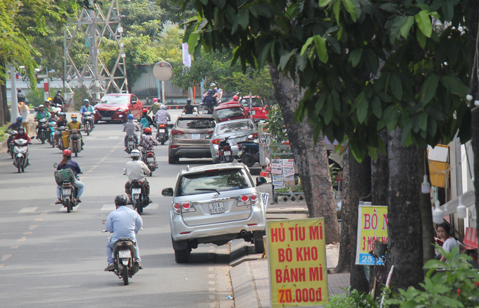 Trong ảnh là bốn ôtô đậu trên vỉa hè đường Hoàng Sa (phường Đa Kao) hàng giờ nhưng không bị xử lý, các biển quảng cáo cũng chiếm trọn lối đi bộ. Nguồn ảnh: Vnexpress