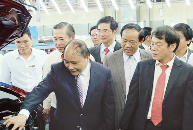 Ông Trần Bá Dương giới thiệu với Thủ tướng Nguyễn Xuân Phúc dòng xe mới tại Khu phức hợp ô tô Chu Lai. Ảnh: Hà Minh/Tiền Phong.