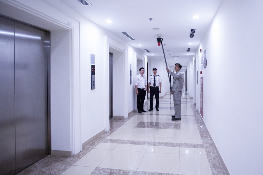 Các bộ phận phối hợp sử dụng thiết bị chuyên dụng kiểm tra định kỳ hệ thống PCCC tại hành lang trong các tòa nhà.