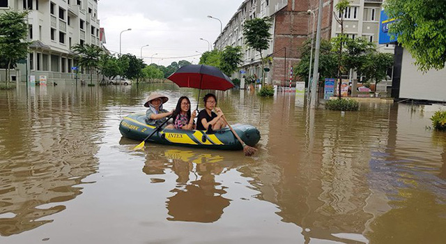 Do sáng nay nước ngập sâu từ 70cm đến gần 1m không thể di chuyển bằng các phương tiện thông thường nên nhiều hộ dân tại khu đô thị Geleximco (Hà Nội) phải đi lại bằng xuồng.