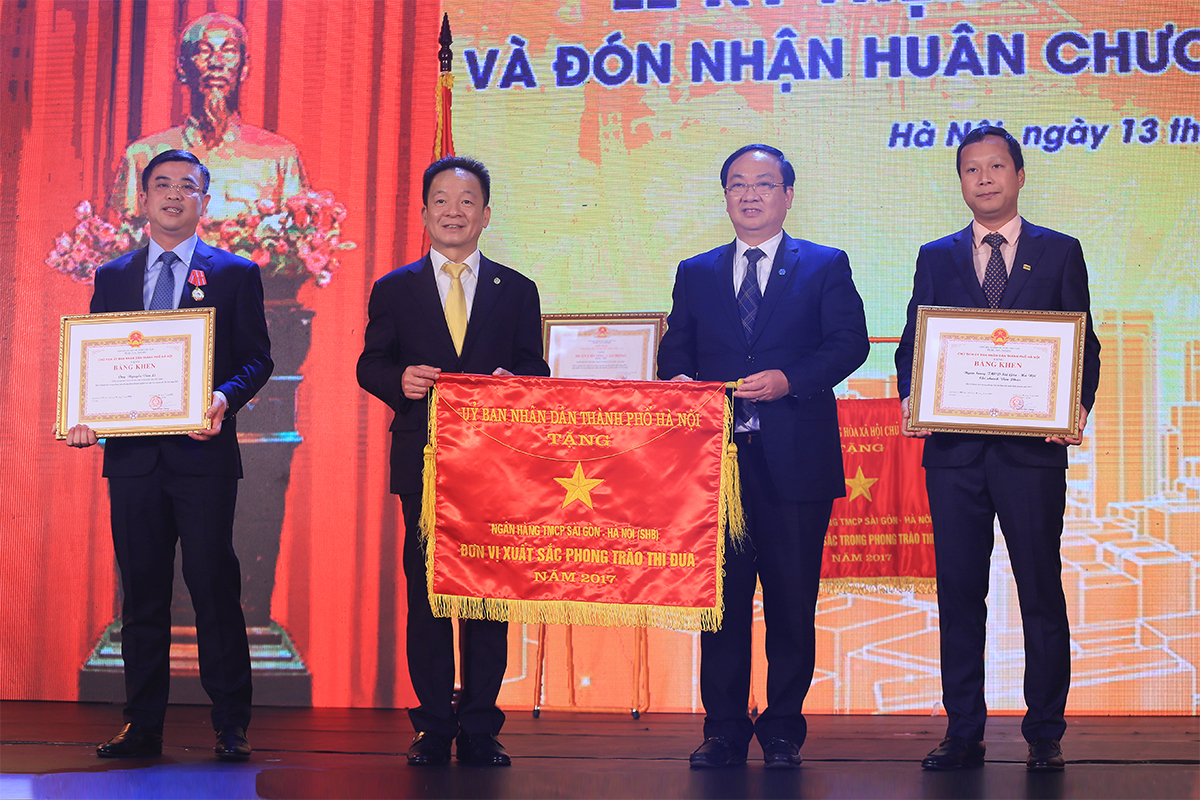  Phó Chủ tịch UBND TP Hà Nội Nguyễn Thế Hùng trao cờ Thi đua và bằng khen của Chủ tịch UBND TP cho các tập thể, cá nhân thuộc SHB vì đã đạt thành tích xuất sắc trong phong trào thi đua, góp phần hoàn thành nhiệm vụ Khối doanh nghiệp năm 2017