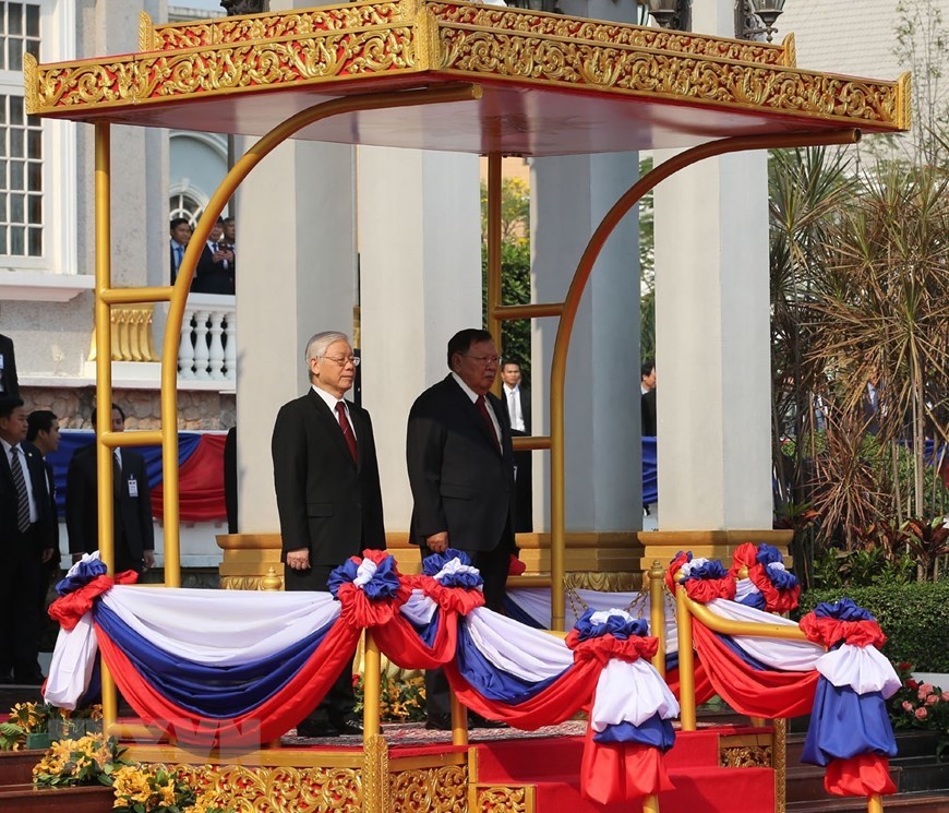 Tổng bí thư, Chủ tịch nước Lào Bounnhang Vorachith và Tổng bí thư, Chủ tịch nước Nguyễn Phú Trọng trên bục danh dự, thực hiện nghi thức chào cờ