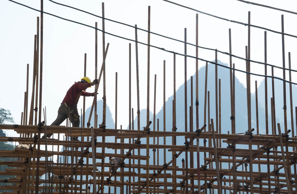 Một công nhân xây dựng trên giàn giáo tre ở Quảng Tây, Trung Quốc. Hình: Chris Goldberg