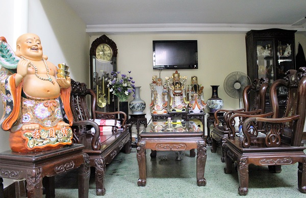 Bộ bàn ghế bằng gỗ lim cùng những bức tượng giúp không gian ngôi nhà đúng phong cách cổ điển.