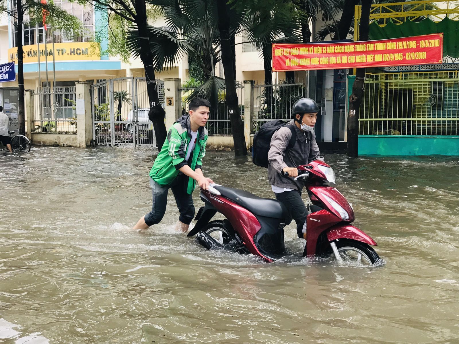 Người dân lội bì bõm giữa dòng nước đục ngàu