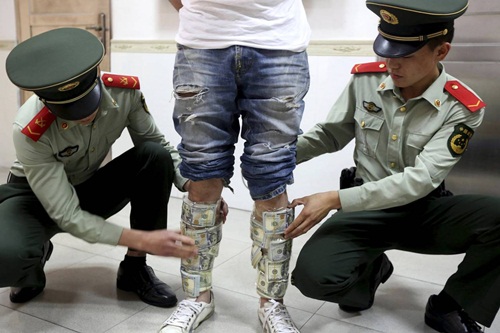 Một người bị bắt vì chuyển tiền lậu từ Trung Quốc sang Hong Kong. Ảnh:Reuters