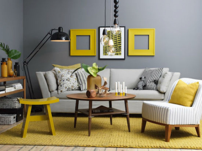 Màu xám tương phản với những khung tranh, tấm thảm và chiếc ghế đẩu màu vàng tạo được sự kích thích thị giác hấp dẫn cho căn phòng.