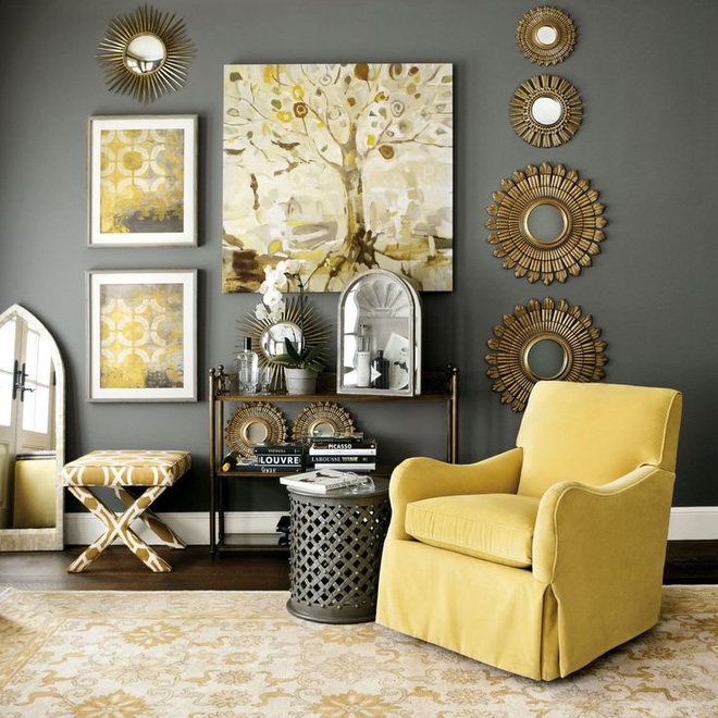 Một phòng khách với tường và chiếc bàn bên tường màu xám đậm hơn giúp tôn lên tông màu vàng tươi của chiếc ghế bành, những bức hoạ màu vàng tươi.
