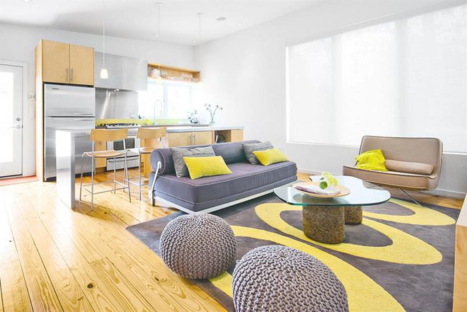 Phòng khách rộng rãi với những chi tiết màu vàng và xám trông rất tươi vui, đặc biệt sàn gỗ màu vàng càng làm tăng thêm cảm giác giống như những ngày nắng hè.