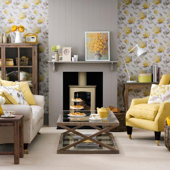 Giấy dán tường hoạ tiết hoa vàng cùng với gối tựa lưng và ghế màu vàng kết hợp với bếp sưởi màu xám càng giúp cho phòng khách có cảm giác ấm cúng.