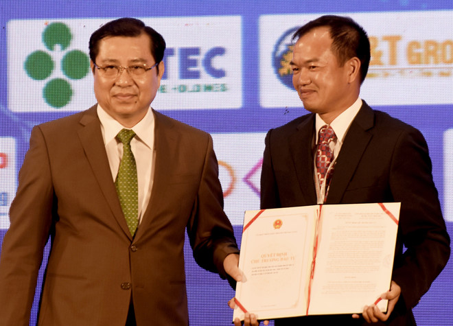 Ông Huỳnh Đức Thơ, Chủ tịch UBND TP Đà Nẵng, trao giấy chứng nhận cho các nhà đầu tư. Ảnh: Minh Hoàng. 