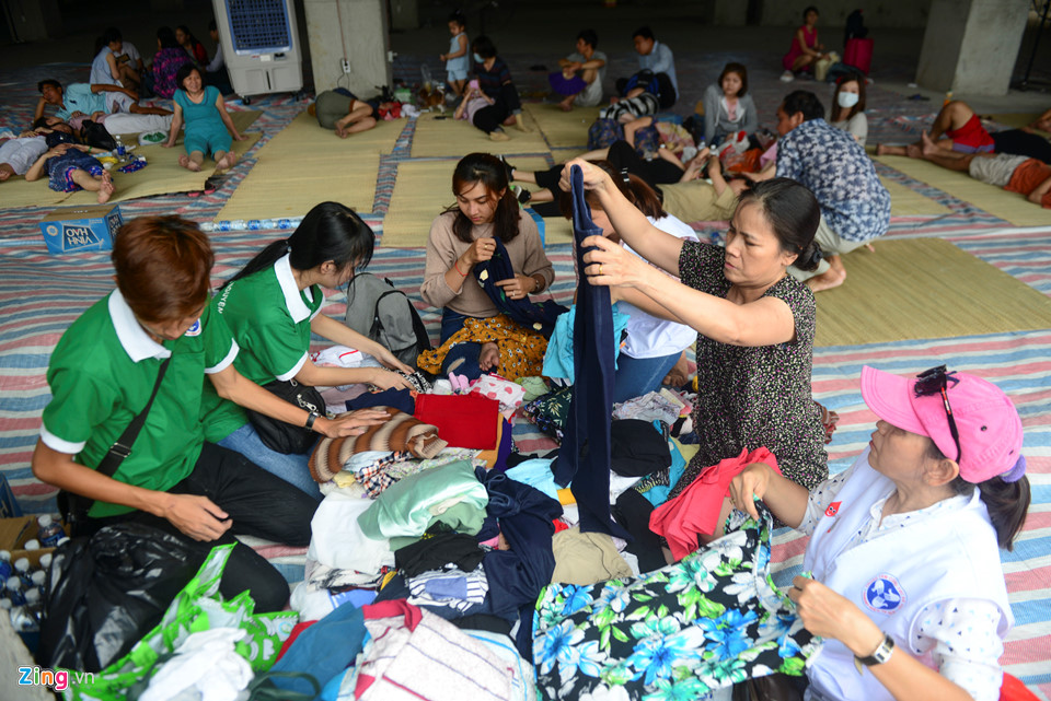 Chị Trần Thị Kim Vân, Trung tâm Công tác xã hội Thành Đoàn, cùng nhóm đang soạn quần áo miễn phí phát cho người dân. Chị cho biết số quần áo này đều do người dân quyên góp, ai cần thì đến chọn mặc.