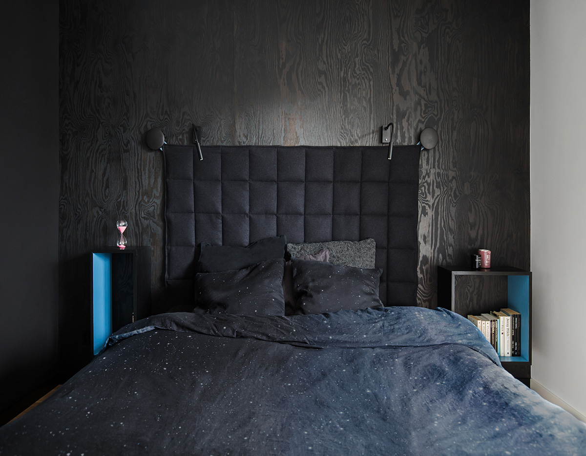 Phòng ngủ lớn lại đi theo phong cách trầm với các tông màu tối hơn so với phần còn lại của ngôi nhà. Phòng ngủ màu đen có tường đầu giường bằng gỗ màu nâu đen, nơi đầu giường có một tấm đệm đen treo trên móc.
