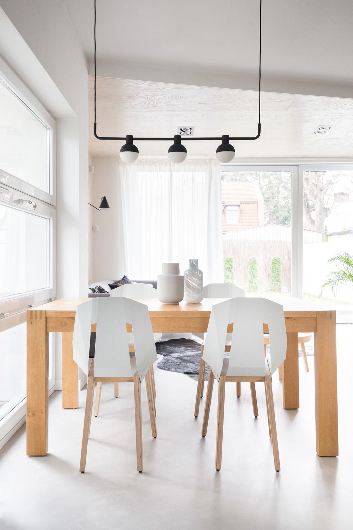 Bộ bàn ghế ăn bằng gỗ với lưng ghế màu trắng hiện đại được sử dụng tại khu vực bếp của ngôi nhà.