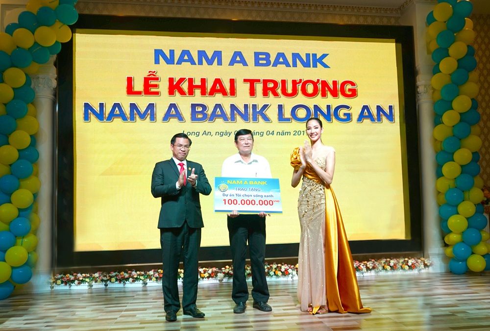 Ông Trần Ngọc Tâm – Tổng Giám đốc Nam A Bank cùng Á hậu Hoàng Thùy trao tặng bảng tượng trưng cam kết về việc triển khai hai dự án vì cộng đồng “Tôi chọn sống xanh” và “Nâng bước đến trường – Thắp sáng tương lai” cho Ông Huỳnh Văn Nhịn – Phó chủ tịch UBND TP Tân An.