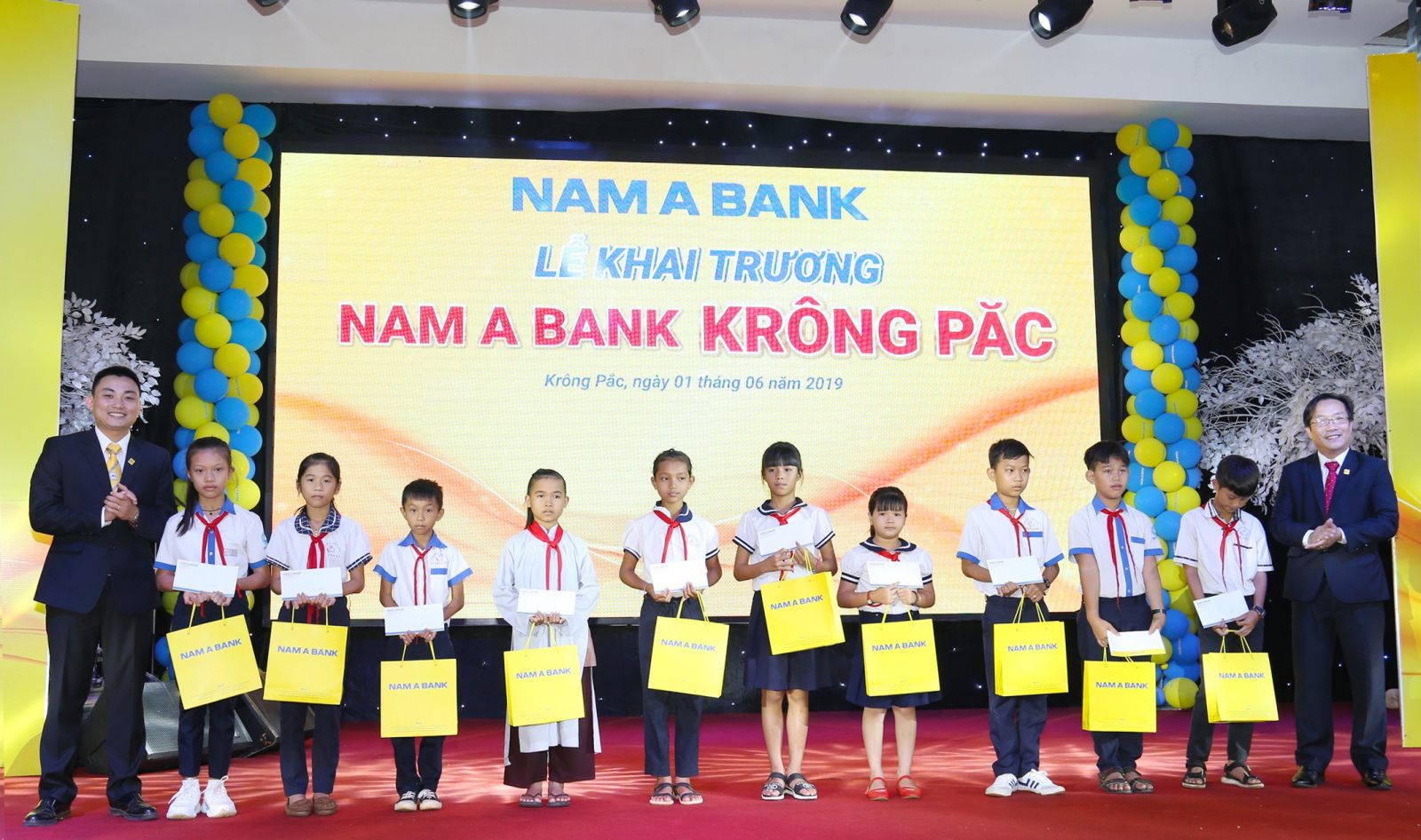 Ông Võ Anh Tú – Giám đốc Nam A Bank Đắk Lắk (bên phải) và Ông Vũ Xuân Phúc – Giám đốc Nam A Bank Krông Păc (bên trái) trao học bổng cho các em  học sinh nghèo vượt khó.